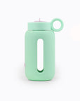 Glass water bottle with a protective silicone sleeve and screw on cap sea foam green.