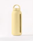 Glass water bottle with a protective silicone sleeve and screw on cap in yellow.