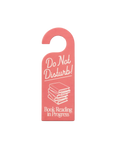 Pink door hanger with 'Do Not Disturb! Book Reading in Progress' text on a gray background