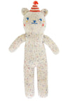Knitted toy bear with colorful face and striped hat on a white background