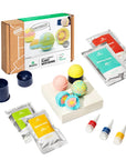 Bath bomb kit with colorful bath bombs, packaging, and ingredients on a white background