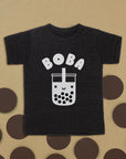 Black tee with screen printed white ink text BOBA above a smiling glass of boba.