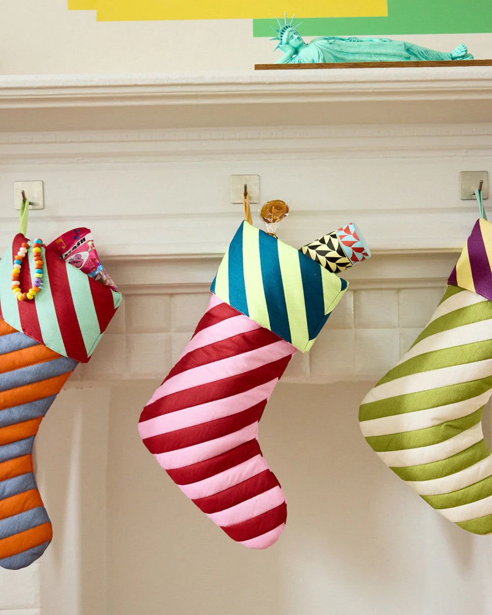 Colorful striped stockings hanging on a fireplace mantle.