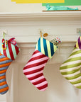 Colorful striped stockings hanging on a fireplace mantle.