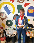 Woman wearing red white and blue LA tee against a colorful background.
