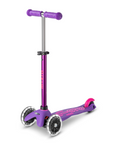 A purple and pink three wheeled push scooter with the front two wheels lit up with LED lights.