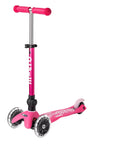 A pink and white three wheeled push scooter with the front two wheels lit up with LED lights.