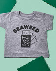 Grey tee screen printed with black ink with text reading SEAWEED above a smiling package of seaweed.