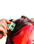 Mini green bread clip hair claw shown clipped in a women's space buns hairstyle.