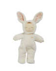A baby doll with closed eyes wearing a white bunny costume.