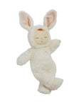 A baby doll with closed eyes wearing a white bunny costume.