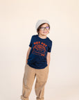 A child modeling a blue tee shirt with red ink screen print of hot pot bowl on a burner and the text HOT POT.