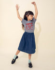 A child modeling a grey tee screen printed with red ink text LUMPIA above three smiling lumpia and dipping sauce.