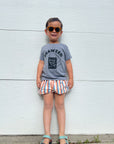 A child modeling a grey tee screen printed with black ink with text reading SEAWEED above a smiling package of seaweed.
