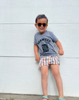A child modeling a grey tee screen printed with black ink with text reading SEAWEED above a smiling package of seaweed.