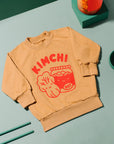 Brown sweatshirt screen printed with red ink, text KIMCHI and cabbage and jar of kimchi, both smiling.