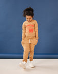 A child modeling brown sweatshirt screen printed with red ink, text KIMCHI and cabbage and jar of kimchi, both smiling.