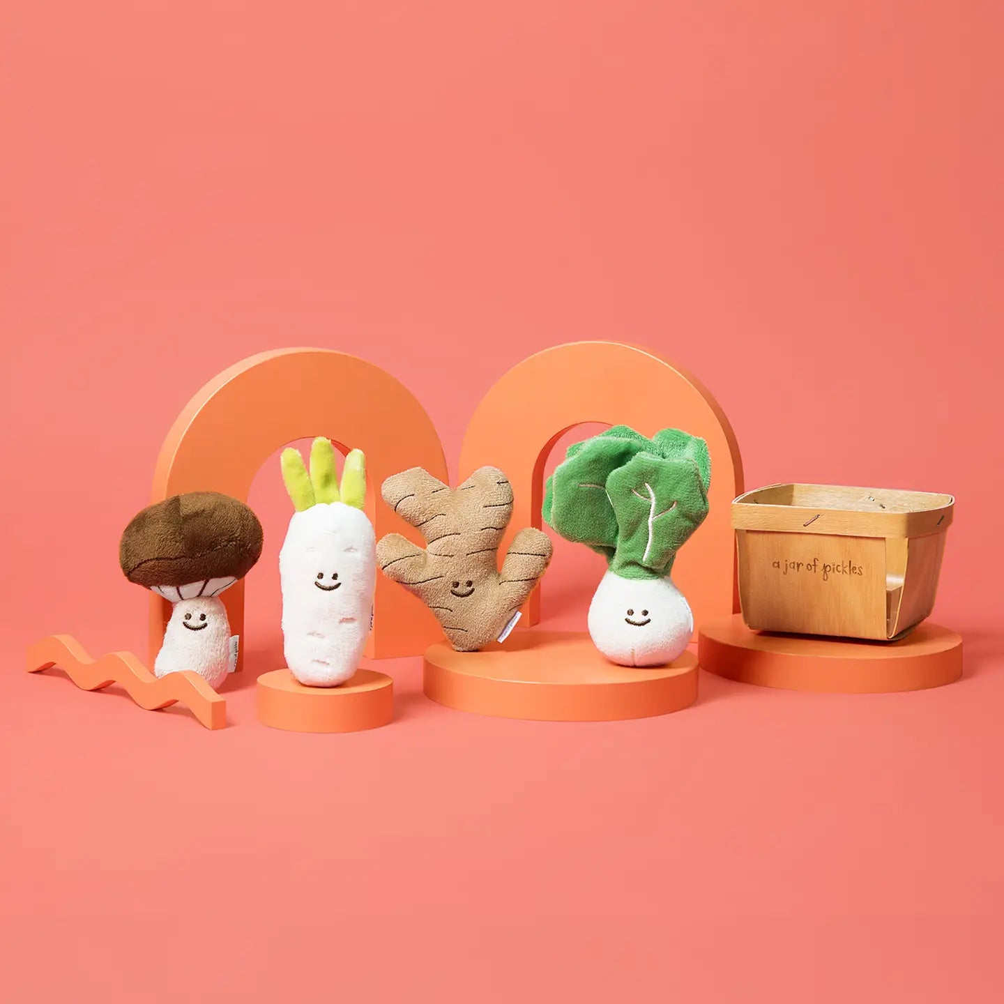 Set of plush vegetable toys on a pink background