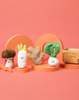 Set of plush vegetable toys on a pink background