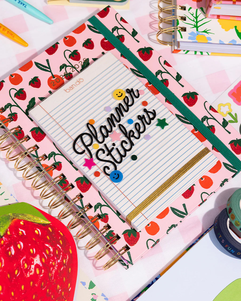 Notebook with strawberry pattern and 'Planner Stickers' text on a colorful background
