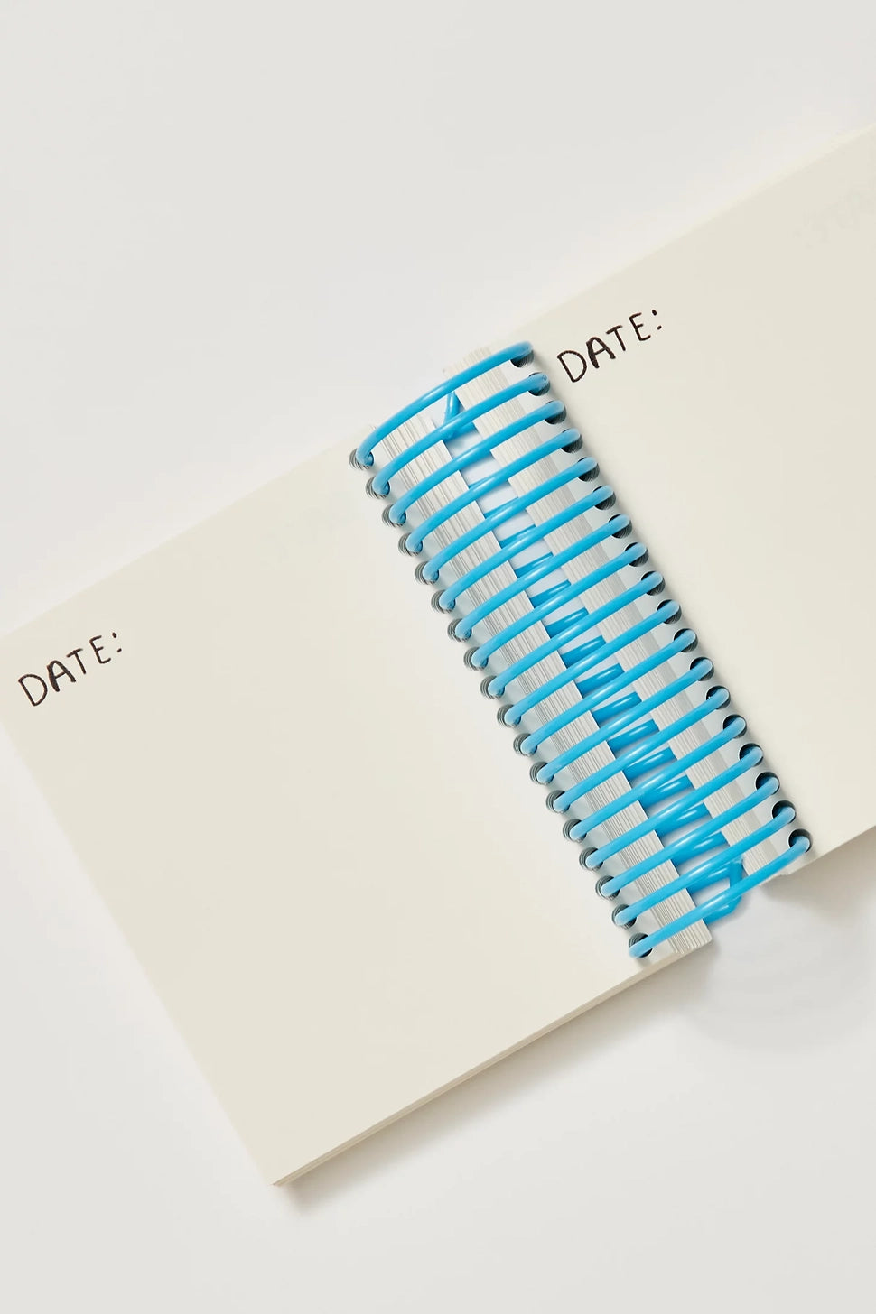 Blue and white spiral notebook on a white surface