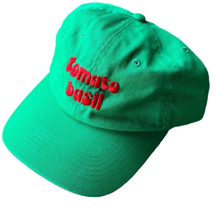 Green cap with red text 'tomato basil' on a white background