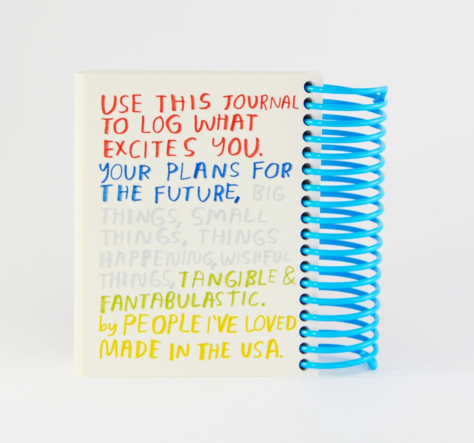 Journal with colorful text and blue spiral binding on a white background