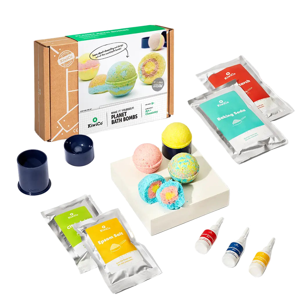 Bath bomb kit with colorful bath bombs, packaging, and ingredients on a white background