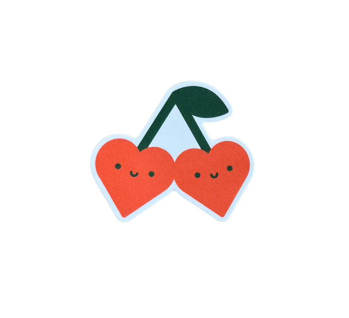 Vinyl sticker of a pair of green and red heart shaped cherries with smiley faces.