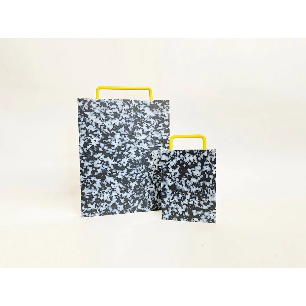 Large and small black and white confetti colored cutting board with a yellow handle on side.