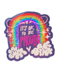 Sparkly  rainbow in the clouds with a smiley face with the words It's Okay To Be Proud.