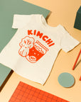 White tee screen printed with red ink, text KIMCHI and cabbage and jar of kimchi, both smiling.