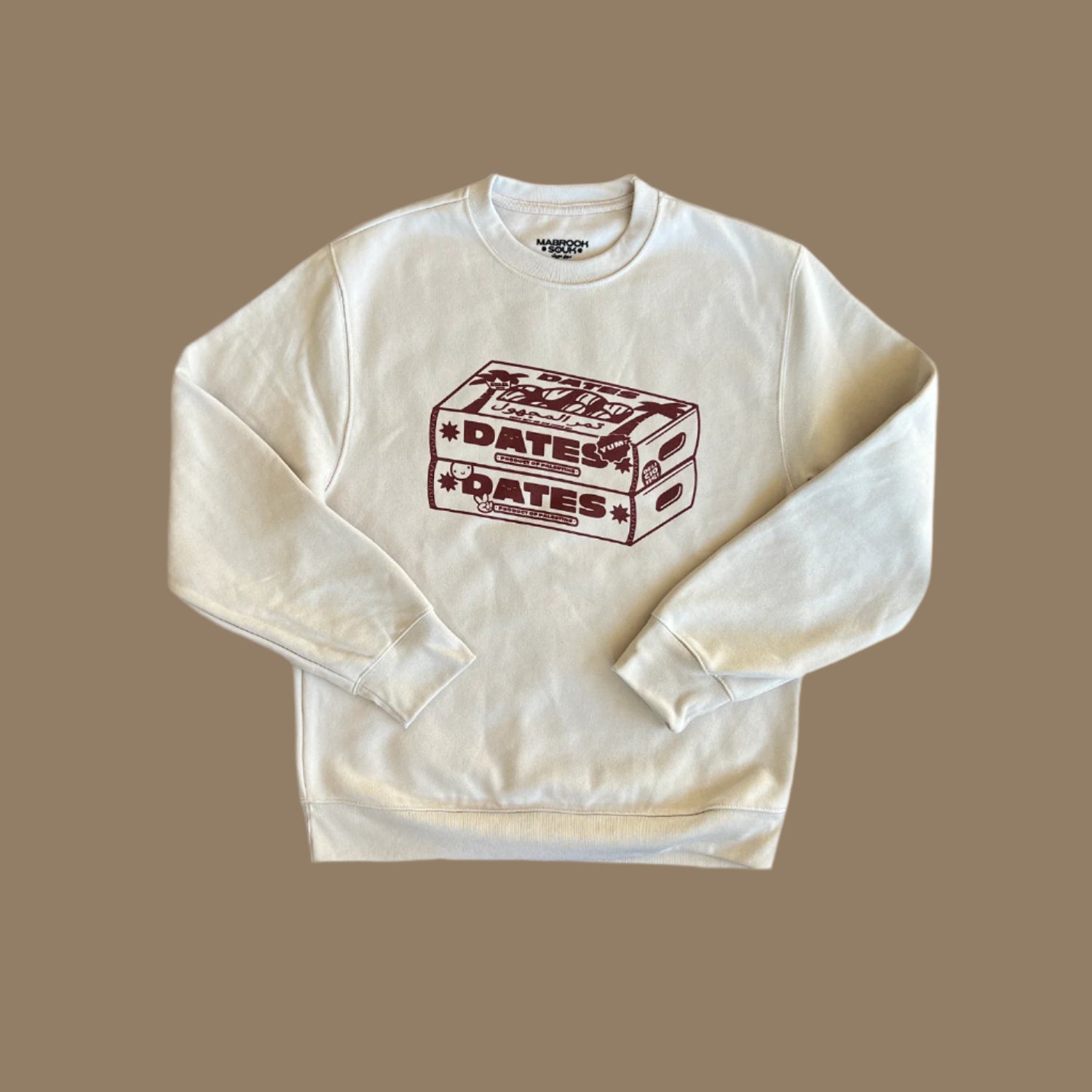 Beige sweater with maroon screen sprint of two boxes of dates with the words Dates, Yum, Made in Palestine on the boxes. 