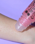 Pink roll-on body glitter being tested on someone's forearm. 