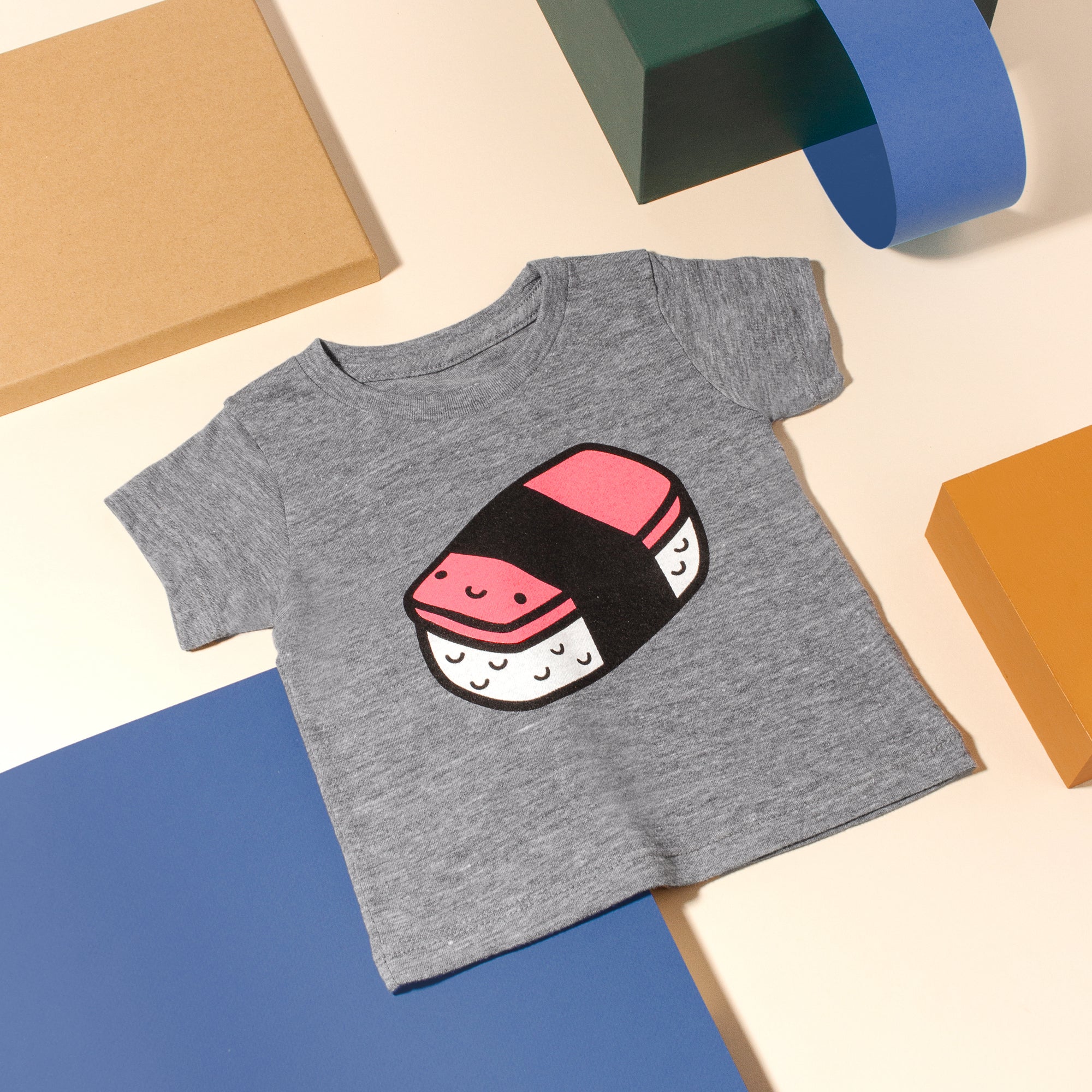Grey tee screen printed with a smiling spam musubi.