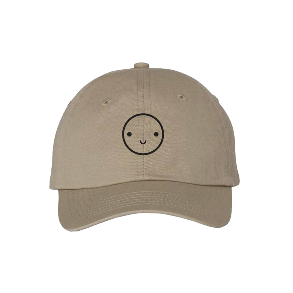 Tan baseball hat with black embroidered smiley face.