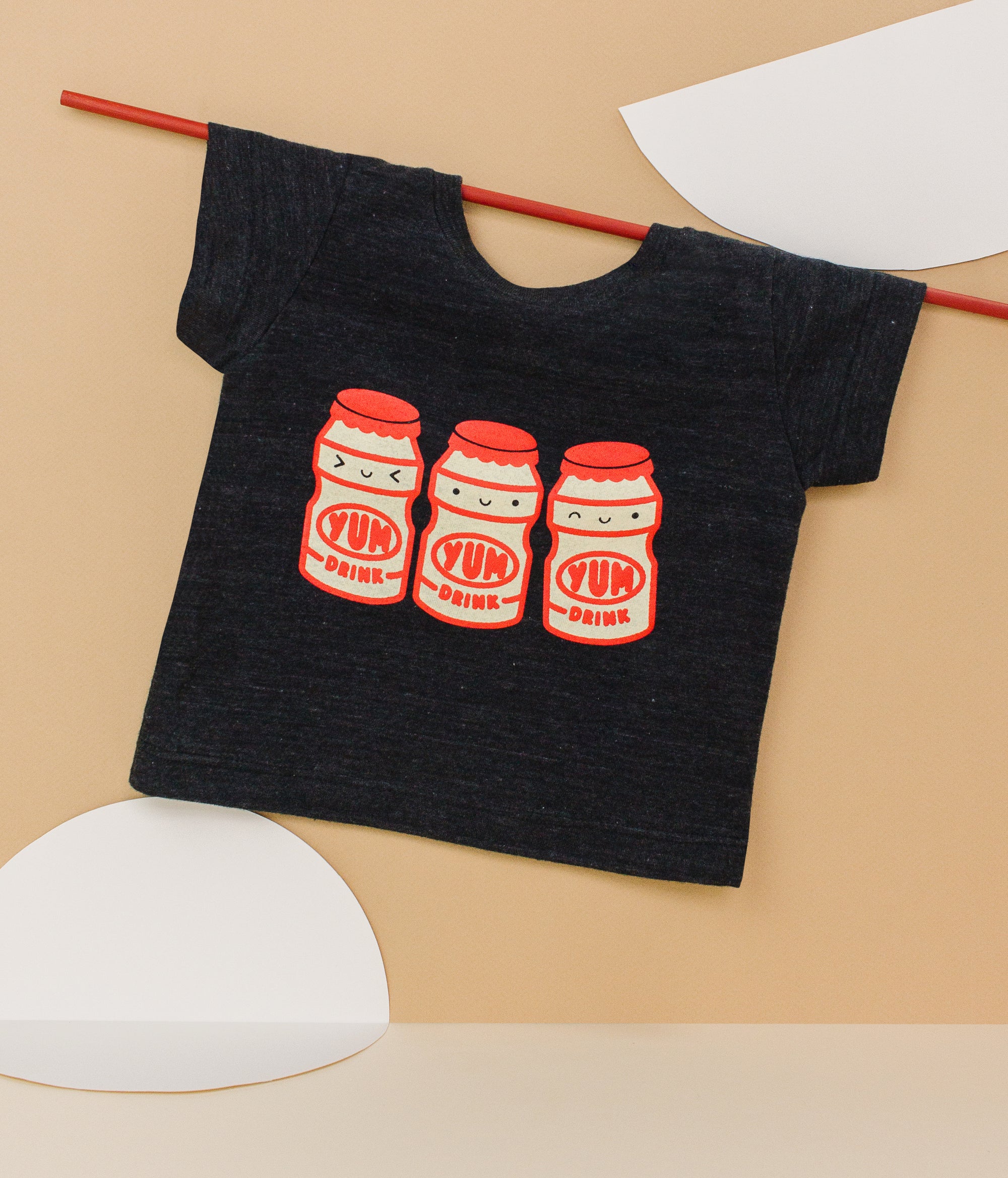 Black tee screen printed with three red and yellow yakult yogurt bottles with smiley faces.