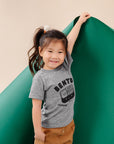 A child modeling a gray tee screen printed with black ink text BENTO above a black smiling bento box lunch with chopsticks.