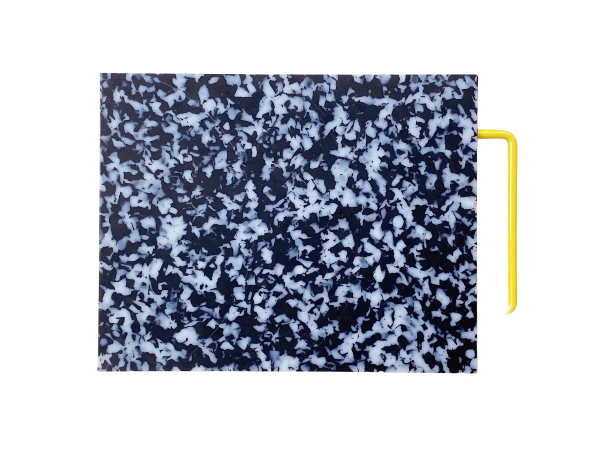 Black and white confetti colored cutting board with a yellow handle on side.
