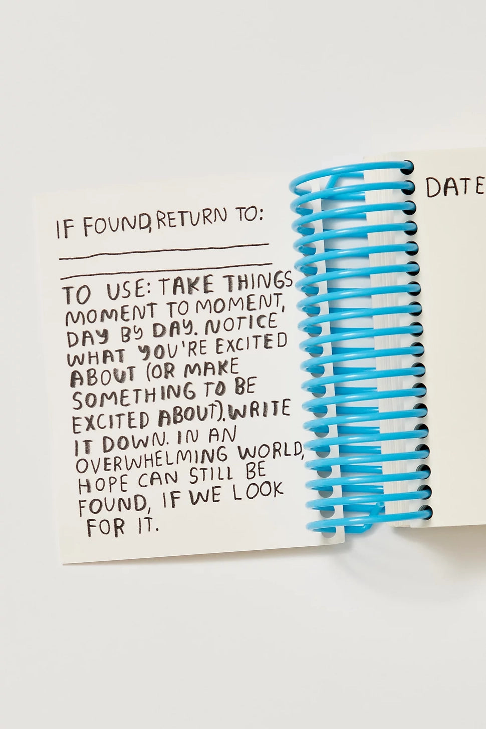 Notebook with text and blue spiral binding on a white background