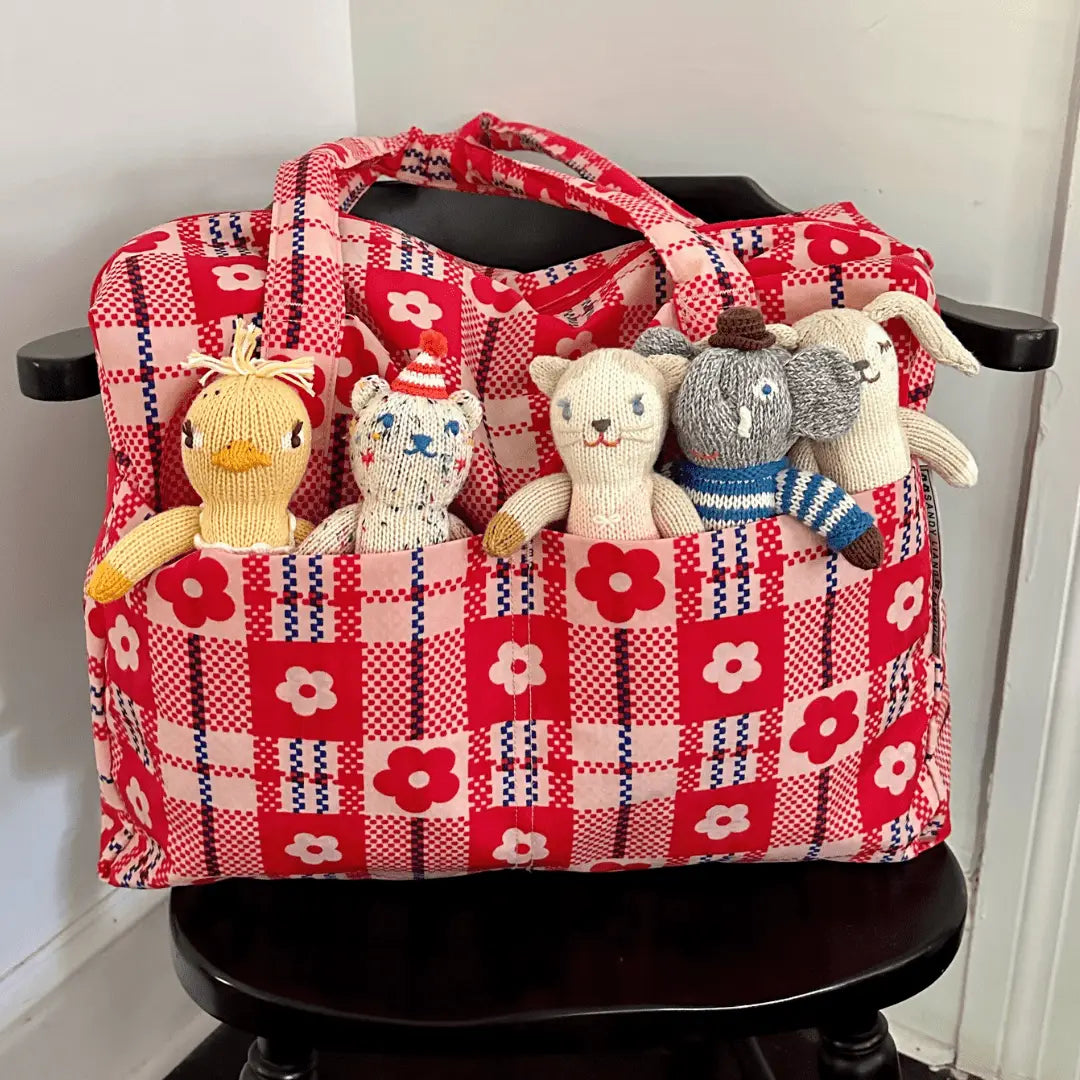 Red checkered bag with stuffed animals on a black chair
