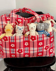 Red checkered bag with stuffed animals on a black chair