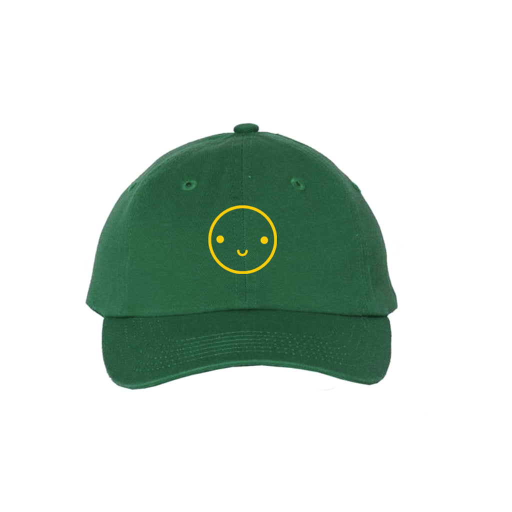 Green baseball hat with yellow embroidered smiley face.