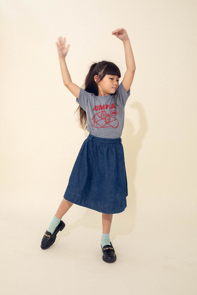 A child modeling a grey tee screen printed with red ink text LUMPIA above three  smiling lumpia and dipping sauce.