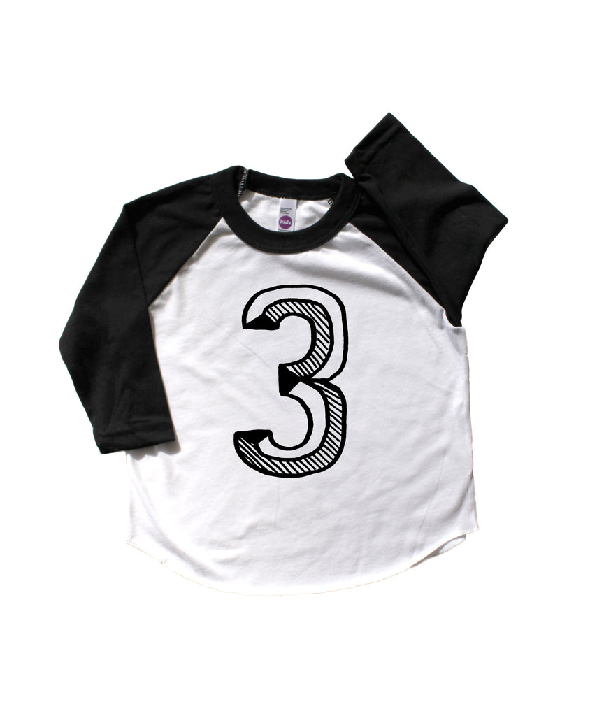 Baseball tee white with black sleeves screen printed with black number 3.